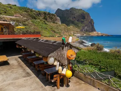 a restaurant with chairs and a view of the ocean at Maiata Beach House by Holiday Rental Madeira in Porto da Cruz