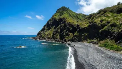 a view of a black beach with a mountain at Maiata Beach House by Holiday Rental Madeira in Porto da Cruz