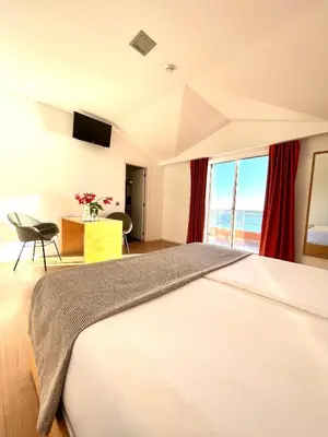 a hotel room with a bed and a view of the ocean at Boutique Hotel Jardim Do Mar in Jardim do Mar