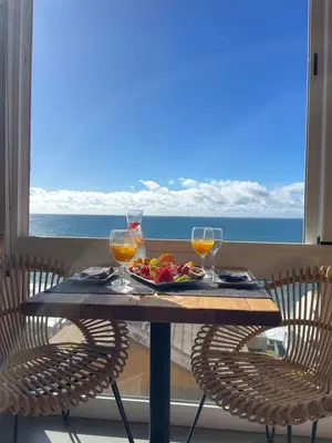 a table with two wine glasses and a plate of fruit at Boutique Hotel Jardim Do Mar in Jardim do Mar