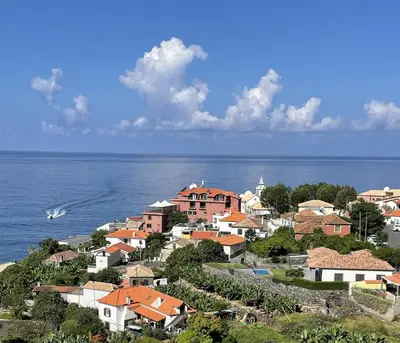 a group of houses on a hill next to the ocean at Boutique Hotel Jardim Do Mar in Jardim do Mar