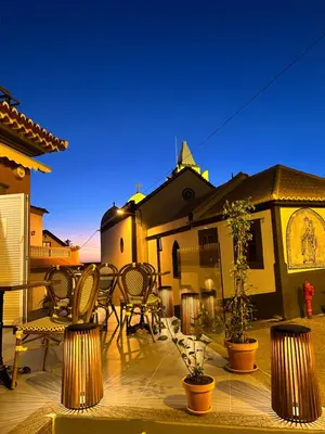 a patio with chairs and tables and a house at Boutique Hotel Jardim Do Mar in Jardim do Mar
