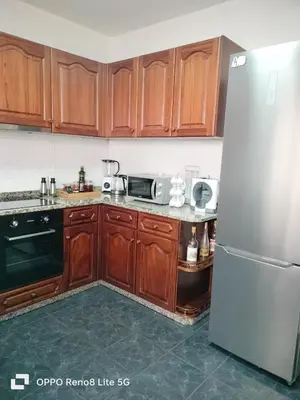 a kitchen with wooden cabinets and a stainless steel refrigerator at casa sousa in Campanário