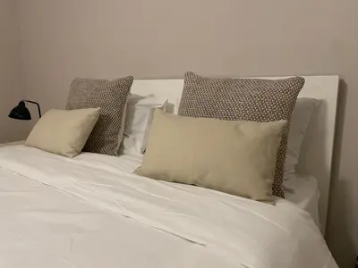 a bed with white sheets and pillows on it at Seminario Classic Apartment in Funchal