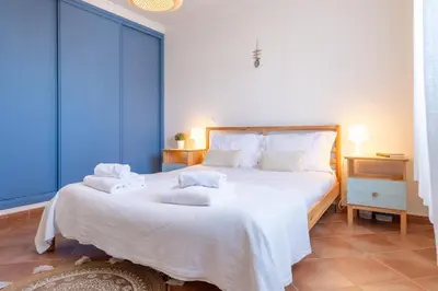 a bedroom with a large bed with towels on it at Arrifana Sunset & Surf in Aljezur