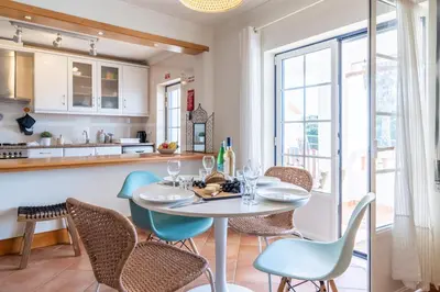 a kitchen and dining room with a table and chairs at Arrifana Sunset & Surf in Aljezur