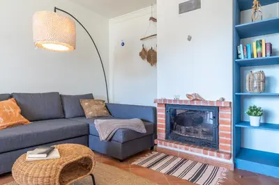 a living room with a couch and a fireplace at Arrifana Sunset & Surf in Aljezur