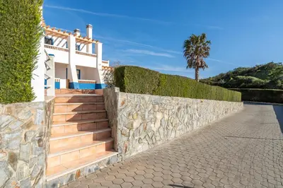 a house with stairs and a stone wall at Arrifana Sunset & Surf in Aljezur
