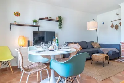 a living room with a table and chairs and a couch at Arrifana Sunset & Surf in Aljezur