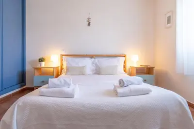 a bedroom with a large white bed with towels on it at Arrifana Sunset & Surf in Aljezur