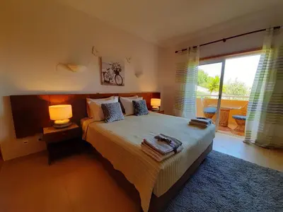 a bedroom with a bed with two lamps and a window at Lucie Lime GuestHouse in Luz