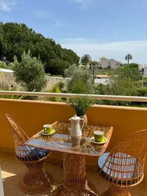 a table with chairs and a tea set on a balcony at Lucie Lime GuestHouse in Luz