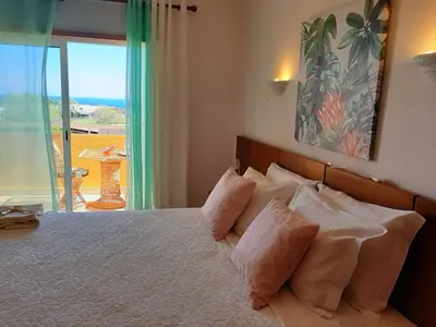 a bedroom with a bed with a view of the ocean at Lucie Lime GuestHouse in Luz