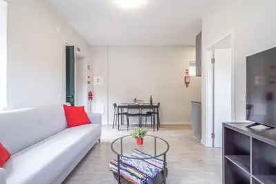 a living room with a white couch and a table at JMF House in São Vicente
