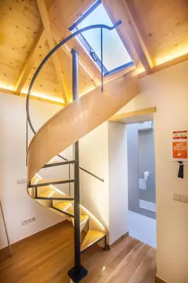 a spiral staircase in a loft with a skylight at Sao Thiago House Madeira in Funchal