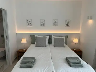 a bedroom with a white bed with two pillows at Feelgood Homestay Sagres in Sagres