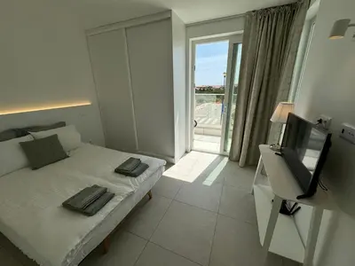 a bedroom with a bed with a television and a window at Feelgood Homestay Sagres in Sagres