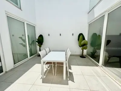 a white table and chairs in a room with windows at Feelgood Homestay Sagres in Sagres