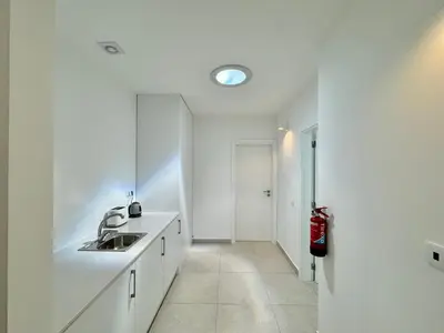 a white kitchen with a sink and a mirror at Feelgood Homestay Sagres in Sagres