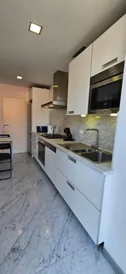 a kitchen with white cabinets and a sink at Plaza Apartamento in Funchal