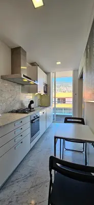 a kitchen with a table and some chairs and a table and a table at Plaza Apartamento in Funchal