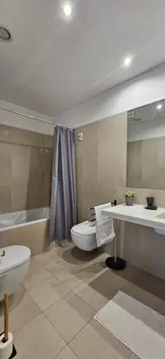 a bathroom with a tub and a toilet and a sink at Plaza Apartamento in Funchal