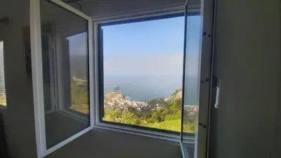 a window in a room with a view of the ocean at Porto à Vista in Porto da Cruz