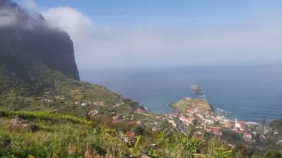 a small town on a hill next to the ocean at Porto à Vista in Porto da Cruz