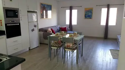 a kitchen and living room with a table and chairs at Porto à Vista in Porto da Cruz