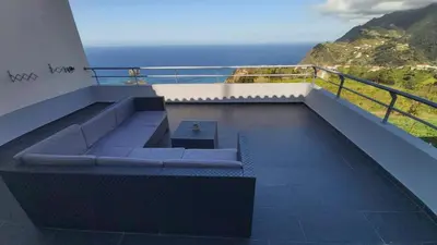 a bench on a balcony with a view of the ocean at Porto à Vista in Porto da Cruz