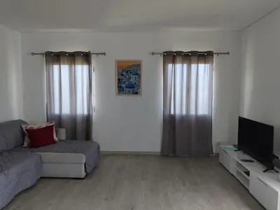 a living room with a couch and a flat screen tv at Porto à Vista in Porto da Cruz