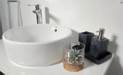 a bathroom counter with a sink and a cup with a cactus at Porto à Vista in Porto da Cruz