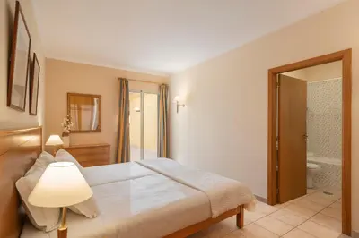 a bedroom with a large bed and a bathroom at Casa do Ribeiro Salgado by An Island Apart in Porto Santo