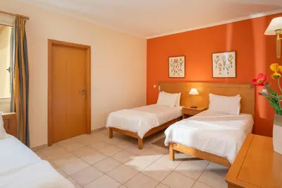 a hotel room with two beds and orange walls at Casa do Ribeiro Salgado by An Island Apart in Porto Santo