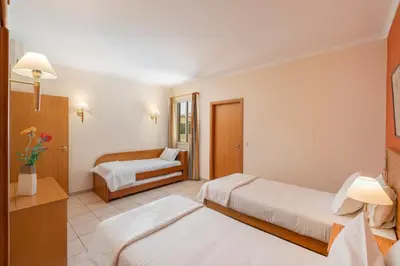 a hotel room with two beds and a chair at Casa do Ribeiro Salgado by An Island Apart in Porto Santo