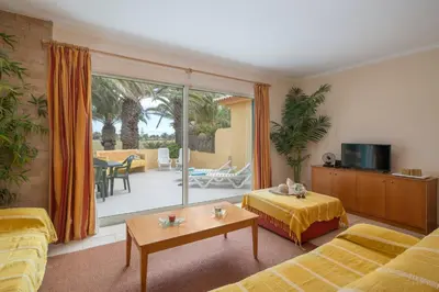a living room with yellow furniture and a patio at Casa do Ribeiro Salgado by An Island Apart in Porto Santo
