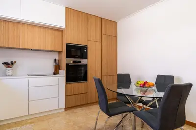 a kitchen with a glass table and chairs in a kitchen at Casa Flor do Campo in Calheta