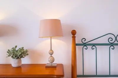 a lamp on a table next to a bed at Casa Flor do Campo in Calheta