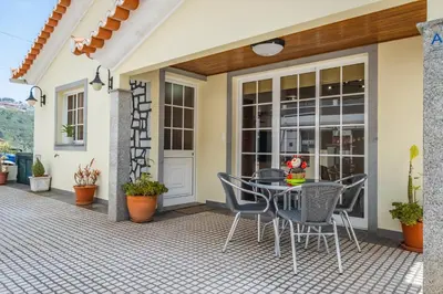a patio with a table and chairs in front of a house at Casa Flor do Campo in Calheta