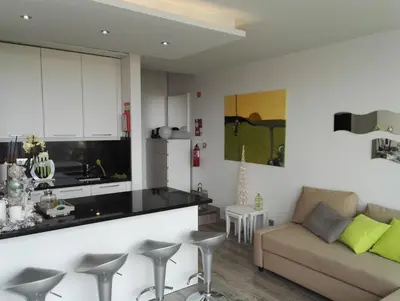 a kitchen and a living room with a couch at Ventur Balcony in Caniço