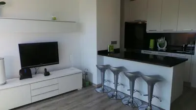 a kitchen with a counter with four bar stools at Ventur Balcony in Caniço