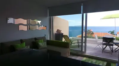 a living room with a couch and a view of a patio at Ventur Balcony in Caniço