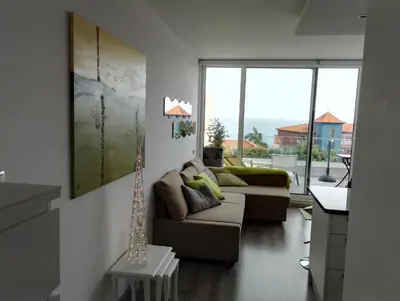 a living room with two couches and a table at Ventur Balcony in Caniço