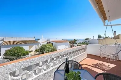 a balcony with a table and chairs and a view of the ocean at Casa Serra e Mar in Luz