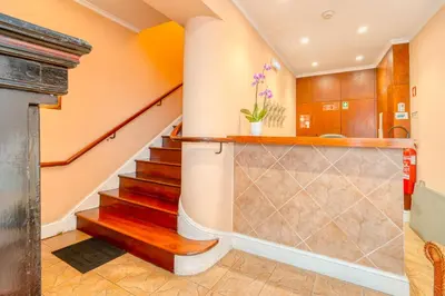 a staircase in a home with orange walls and wooden stairs at O Cantinho da Mariazinha by Amazing Madeira in Funchal