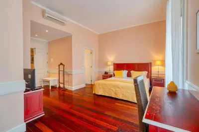 a bedroom with a bed and a desk and a television at O Cantinho da Mariazinha by Amazing Madeira in Funchal