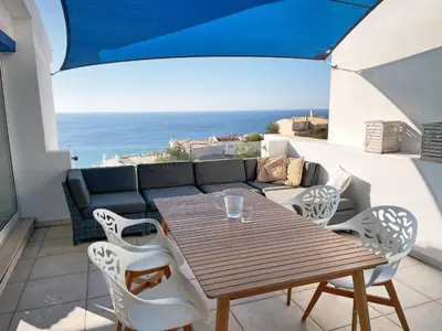 a table and chairs on a balcony with a view of the ocean at 414 Casa Colina Mar in Salema