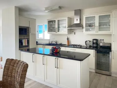 a kitchen with white cabinets and a black counter top at 414 Casa Colina Mar in Salema