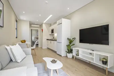 a living room with a white couch and a flat screen tv at Casa da Oliveira by Homie in Caniço