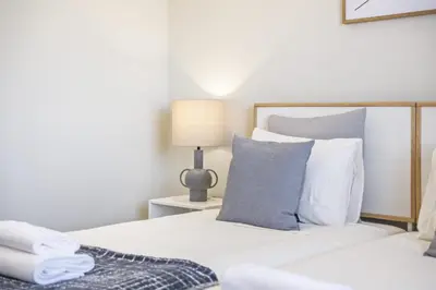 a bedroom with a white bed and a lamp at Casa da Oliveira by Homie in Caniço